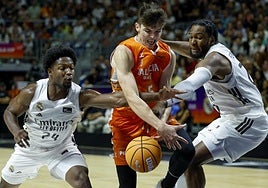 De Larrea recibe falta de dos jugadores del Madrid.