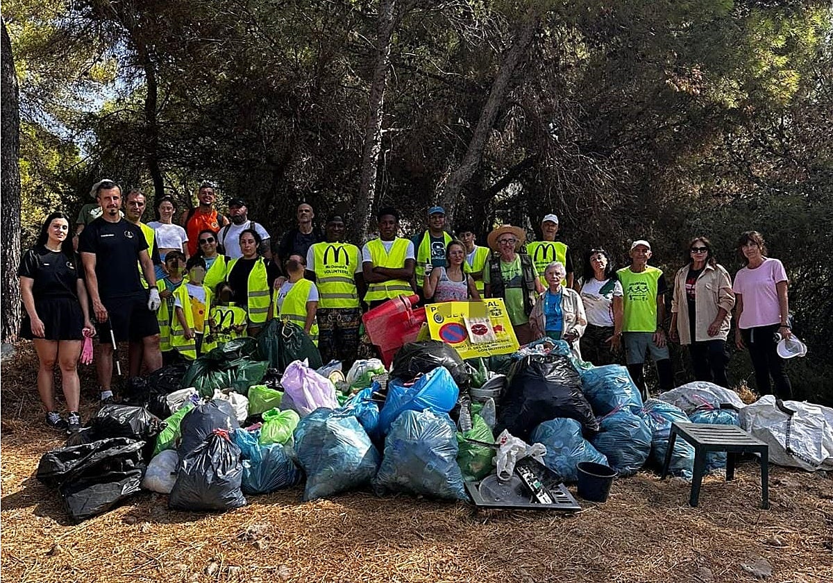 Los participantes posan con las bolsas de residuos retirados.