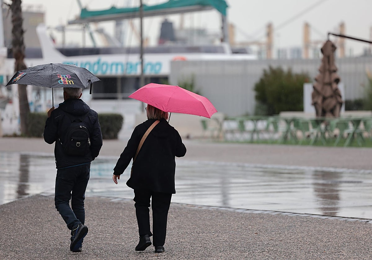 Dos visitantes pasean por el Muelle Uno en un episodio anterior de lluvias.