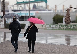 Dos visitantes pasean por el Muelle Uno en un episodio anterior de lluvias.