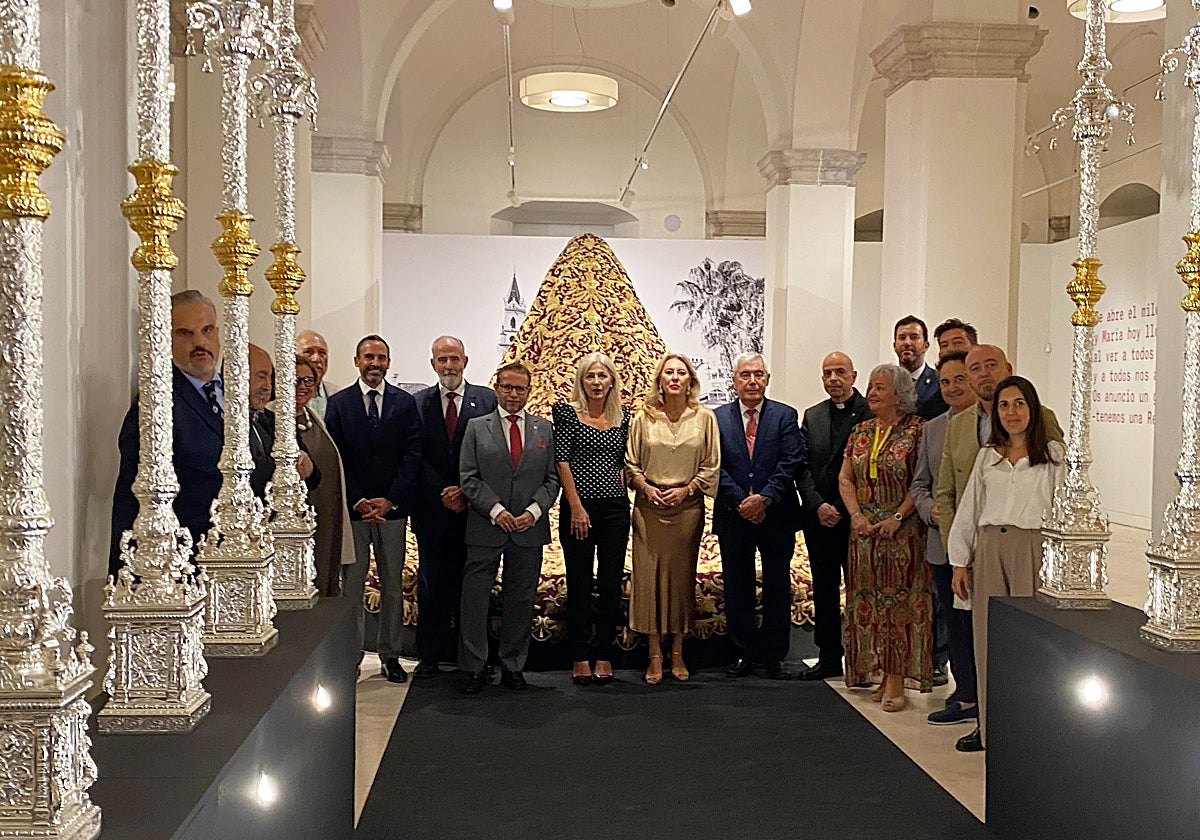 Autoridades y cofrades ante el palio y manto procesional de la Virgen de la Trinidad.