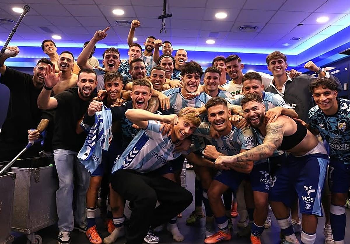 Dean Huijsen celebra la victoria del Málaga en el vestuario con los futbolistas blanquiazules.