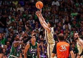 Juani Marcos lanza un triple ante Perry ante la mirada del colegiado Emilio Pérez Pizarro.