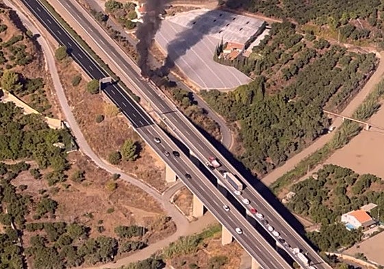 Imagen aérea del vehículo incendiado este viernes en la autovía a la altura de Nerja.