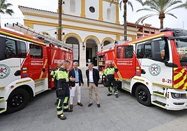 Los concejales José Eduardo Díaz y Javier García junto a dos de los camiones en la plaza de la iglesia de San Pedro.