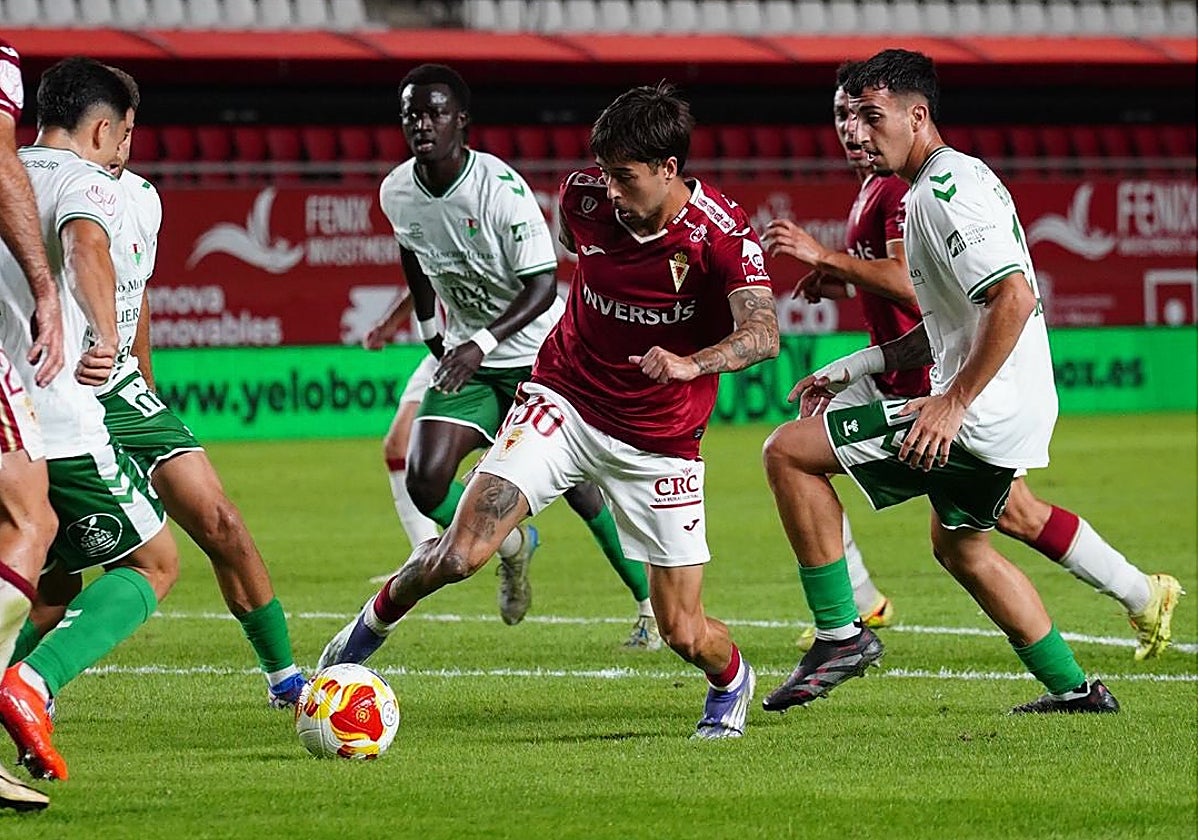 Un jugador del Real Murcia trata de controlar en el área del Antequera.