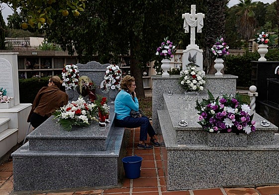 Dos mujeres acompañan a sus seres queridos en el cementerio de San Gabriel.