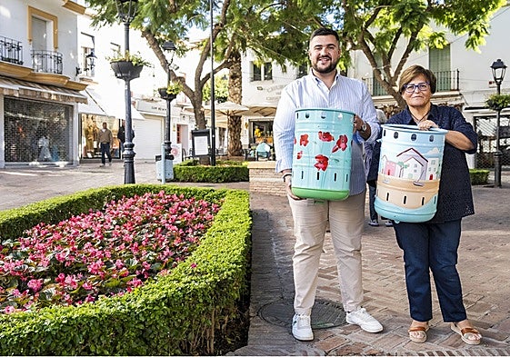 El concejal del distrito Oeste, Alejandro González, y la asesora responsable de Comercio, Carmina Serrano, posan con dos de las papeleras decorativas.
