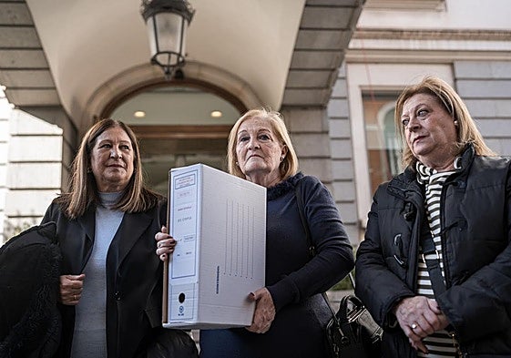 Las hermanas García Caparrós con una de las cajas con la documentación, este martes en el Congreso de los Diputados.