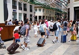 Turistas se dirigen a sus alojamientos por el Centro de Málaga.