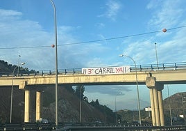 Pancarta que reclama el tercer carril colocada en la variante de Rincón.
