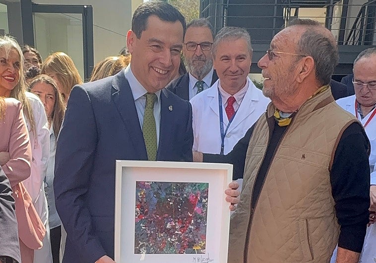 Manolo Rincón regala a Juanma Moreno uno de sus cuadros con un mensaje de «concordia»