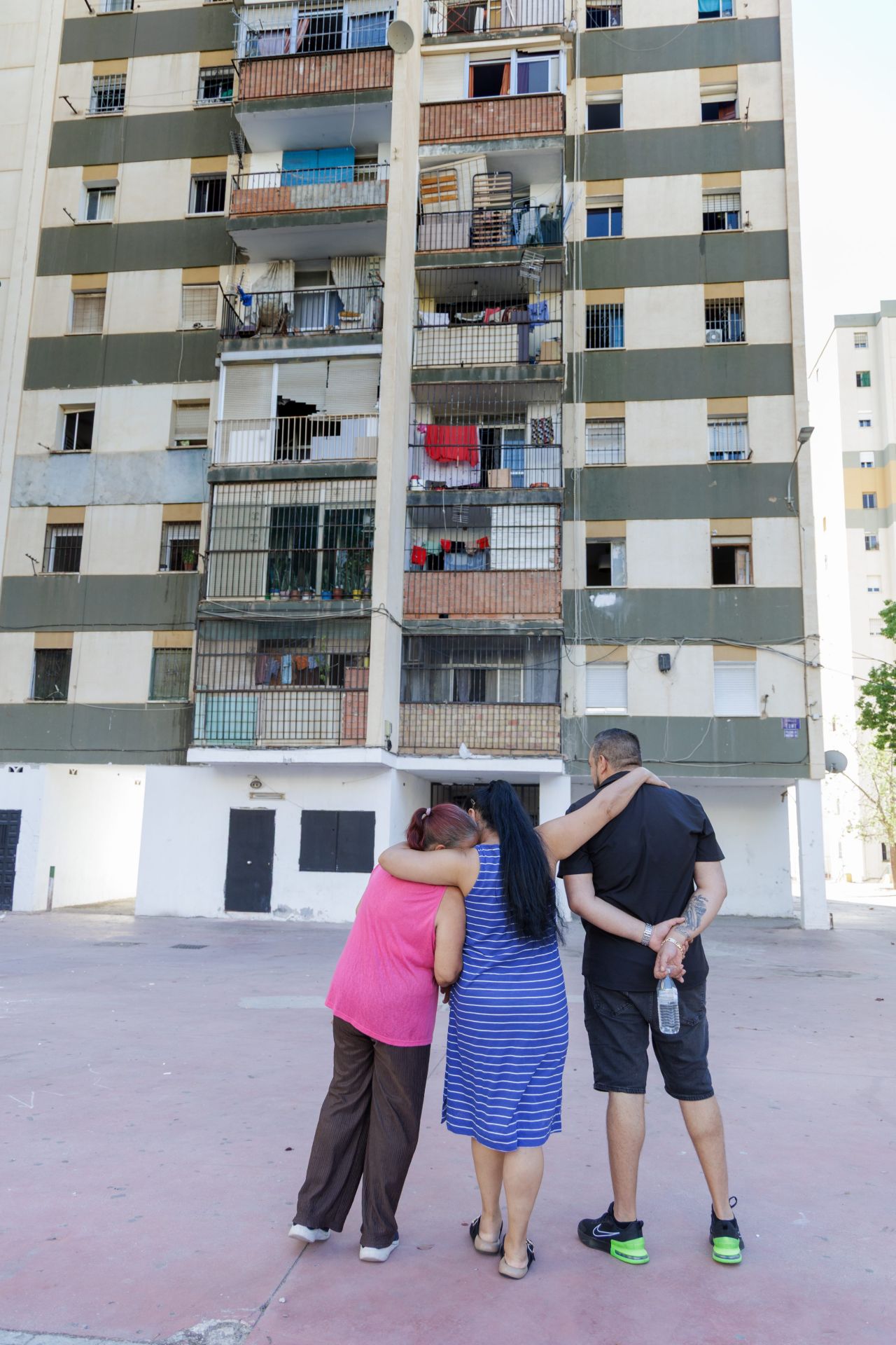 Francisca Godoy, Mari Reyes Vázquez y Francisco Martín, frente a su bloque al que han cortado la luz.