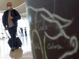 Un pasajero con mascarilla se dirige a la zona de embarque en el área de salidas de la T4 del Aeropuerto de Madrid-Barajas  / Efe