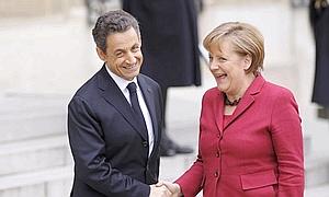 Angel Merkel saluda a Nicolas Sarkozy durante la cumbre de París. / Reuters