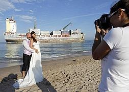Una pareja de novios se fotografía ante uno de los buques. / Efe