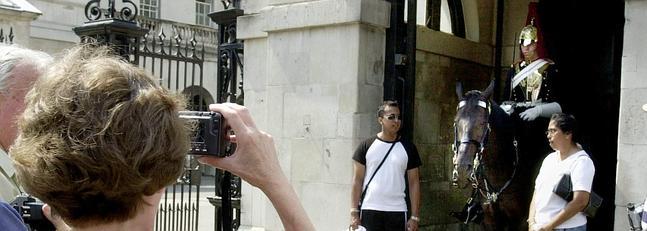 Turistas posando junto a un guardia antes del cambio de guardia inglesa. / Richard Lewis (Ap)
