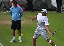 Nadal (d) es observado por Toni Nadal en una pista de Wimbledon. / Carl Court (AFP)