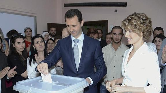 Bachar Al Asad (2ºdcha) ejerce su derecho al voto junto a su mujer