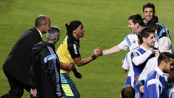 Un doble de Ronaldinho saluda a Messi. 