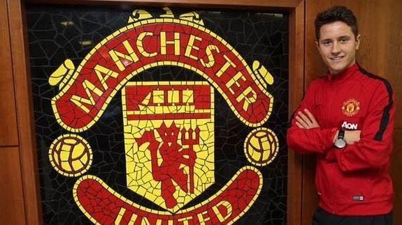 Ander Herrera posa junto al escudo del Manchester United. 