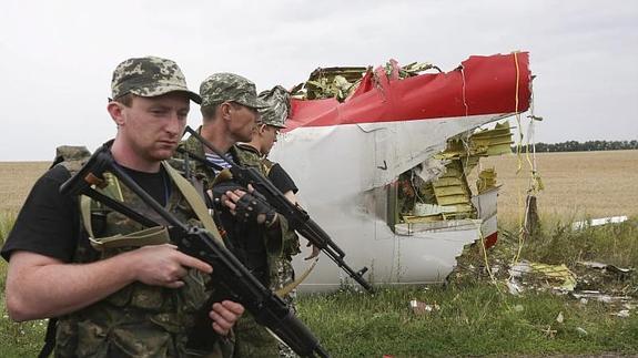 Rebeldes prorrusos, apostados al lado de restos del Boeing 777.