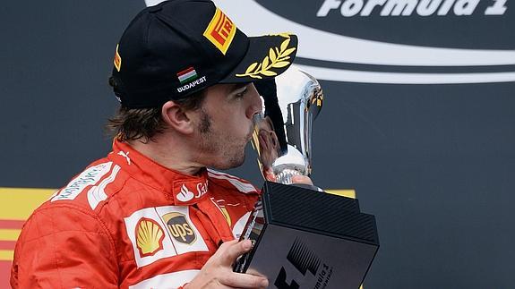 Alonso besa su trofeo en el podio de Hungría. 