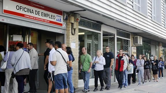 Varias personas en la cola de una oficina de empleo.