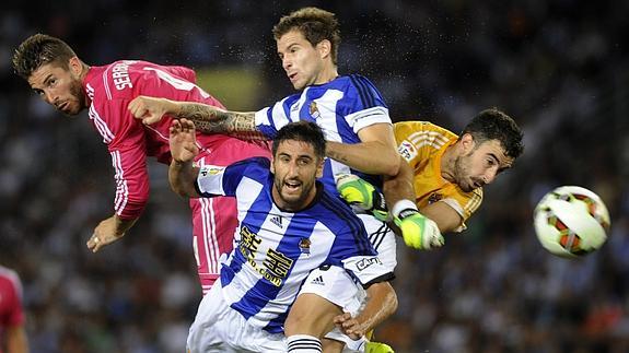 Ramos (i) cabecea ante los defensas de la Real. 