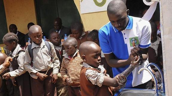 Niños nigerianos lavándose las manos como método de prevención.