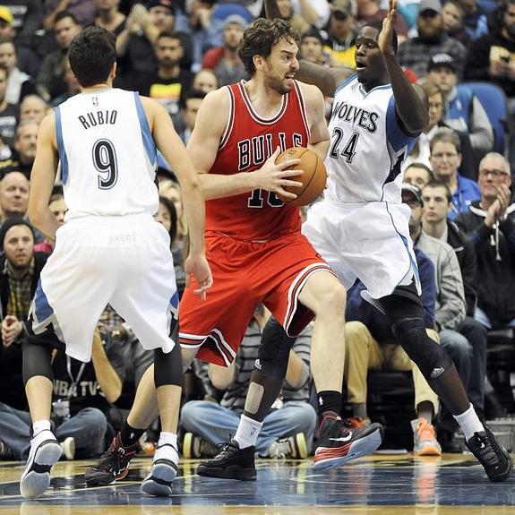 Pau Gasol (c) en acción ante la defensa de Ricky Rubio (i) y Anthony Bennett (d).