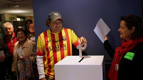 Un ciudadano deposita su papeleta en un punto habilitado en la Vía Augusta de Barcelona 