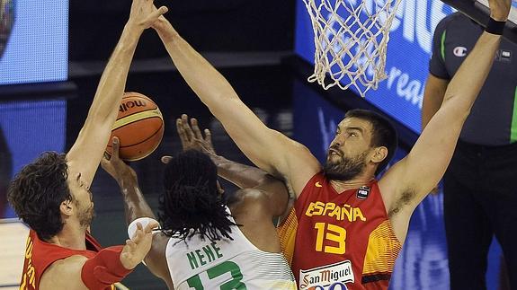 Pau y Marc Gasol, ante el brasileño Nené Hilario.  