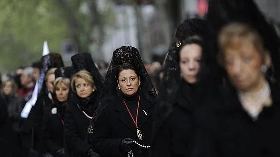 Mujeres, con la tradicional mantilla negra, participan en una procesión.