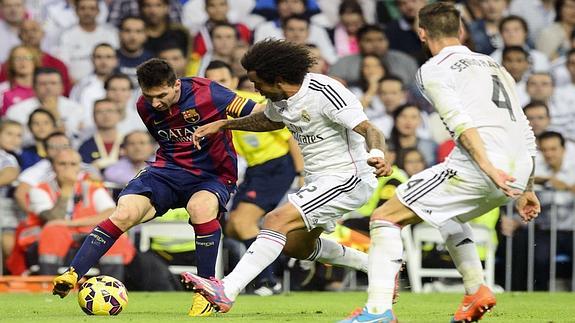 Messi (i) regatea ante Marcelo y Ramos. 