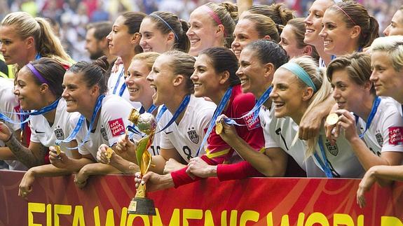 La selección estadounidense femenina de fútbol posa con el trofeo. 