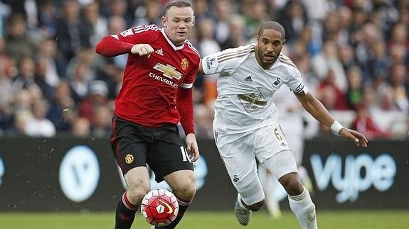 Wayne Rooney (izq.) y Ashley Williams (der.). 