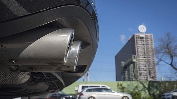 Un tubo de escape y, al fondo, una sede de Volkswagen.