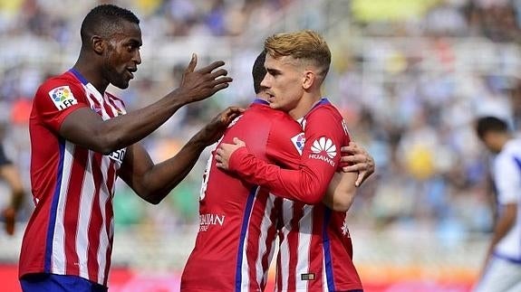 Griezmann es felicitado por sus compañeros tras marcar el primer gol . 