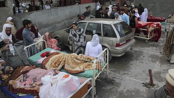 Heridos reciben atención médica en el aparcamiento de un hospital en Abbotabad.