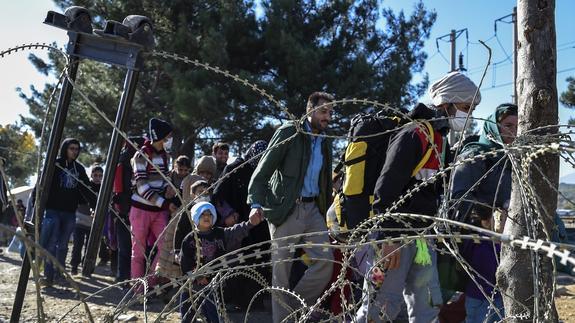 Un grupo de refugiados cruza la frontera entre Grecia y Macedonia.