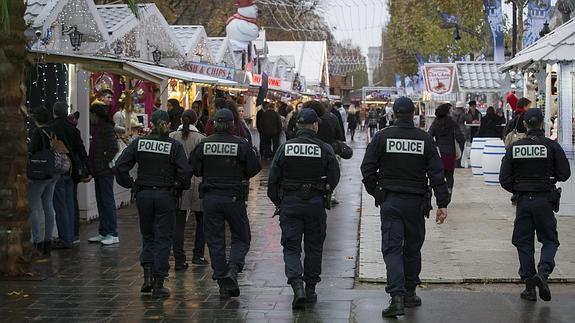 Policías patrullan un mercado navideño en los Campos Elíseos de París.