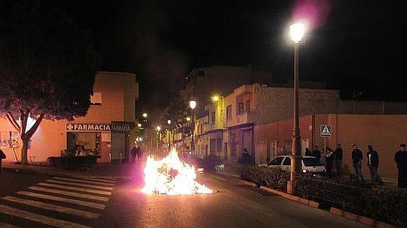 Un contenedor arde en el centro de la calle.