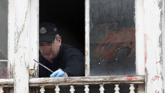 Un ertzaina toma pruebas en la ventana del domicilio. 