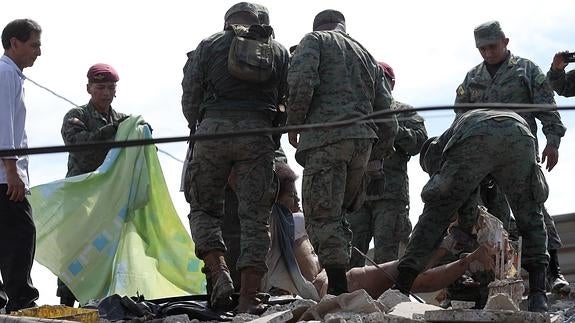 Autoridades y pobladores rescatan un cuerpo entre los escombros en la localidad de Pedernales (Ecuador).