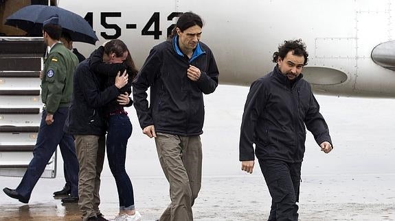 Ángel Sastre (d), José Manuel López (c) y Antonio Pampliega (i, abrazando a un familiar), a su llegada.