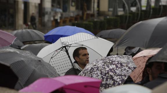 Habitantes de Vitoria se protegen de la lluvia con los paraguas.