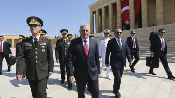 El primer ministro turco, Binali Yildirim (c), y el jefe del Estado Mayor del Ejército, Hulusi Akar (i). 