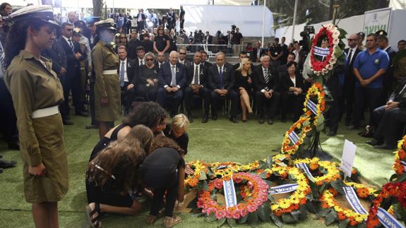 Los nietos de Simón Peres depositan una corona de flores en recuerdo de su abuelo.