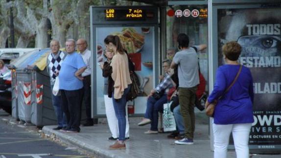 Varias personas en una parada de la EMT en Valencia.